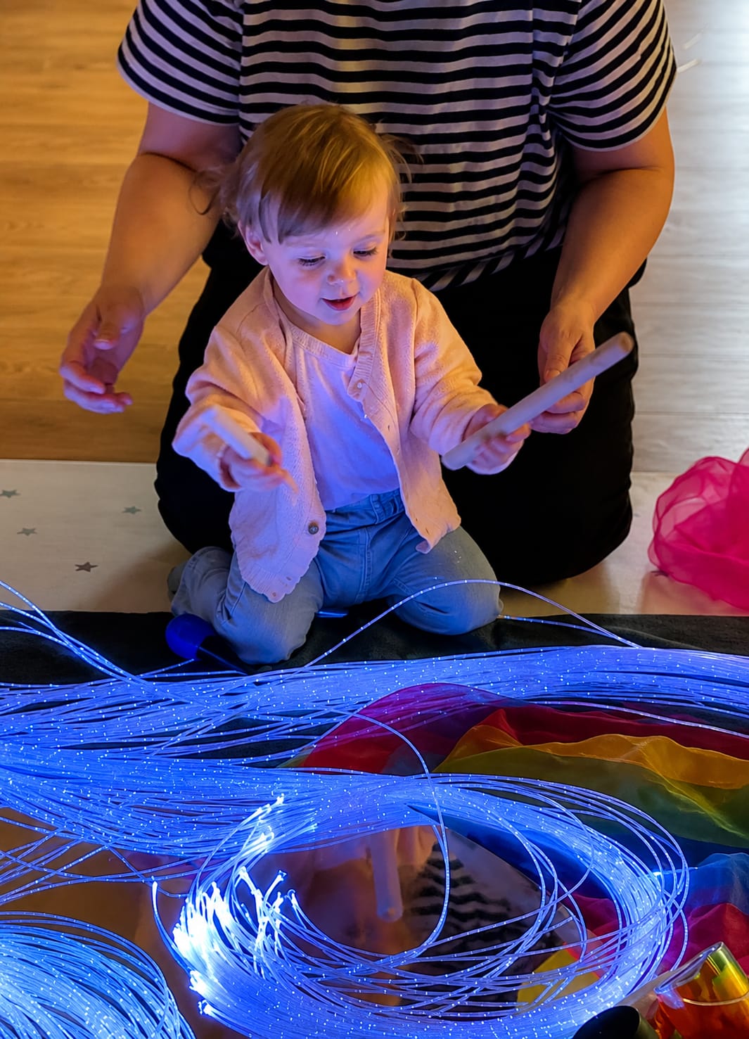Toddler exploring fibre-optic sensory lights at a Baby Babble NI class